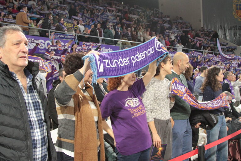 Aficionados animando en las gradas con bufandas del equipo