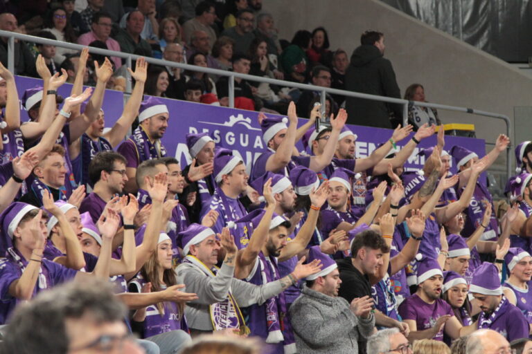 Aficionados animando en las gradas durante un partido de baloncesto.