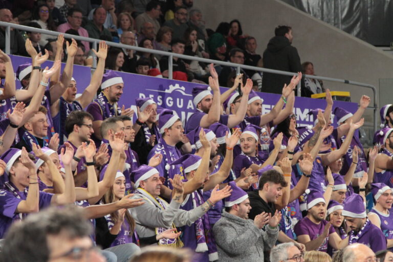 Aficionados animando en las gradas durante un partido de baloncesto.