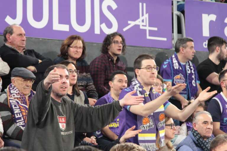 Aficionados animando en las gradas durante un partido de baloncesto.