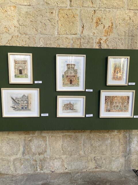 Exposición de arte románico en la catedral de Palencia con varias obras enmarcadas.