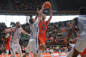 Jugadores de baloncesto en acción durante un partido intenso.
