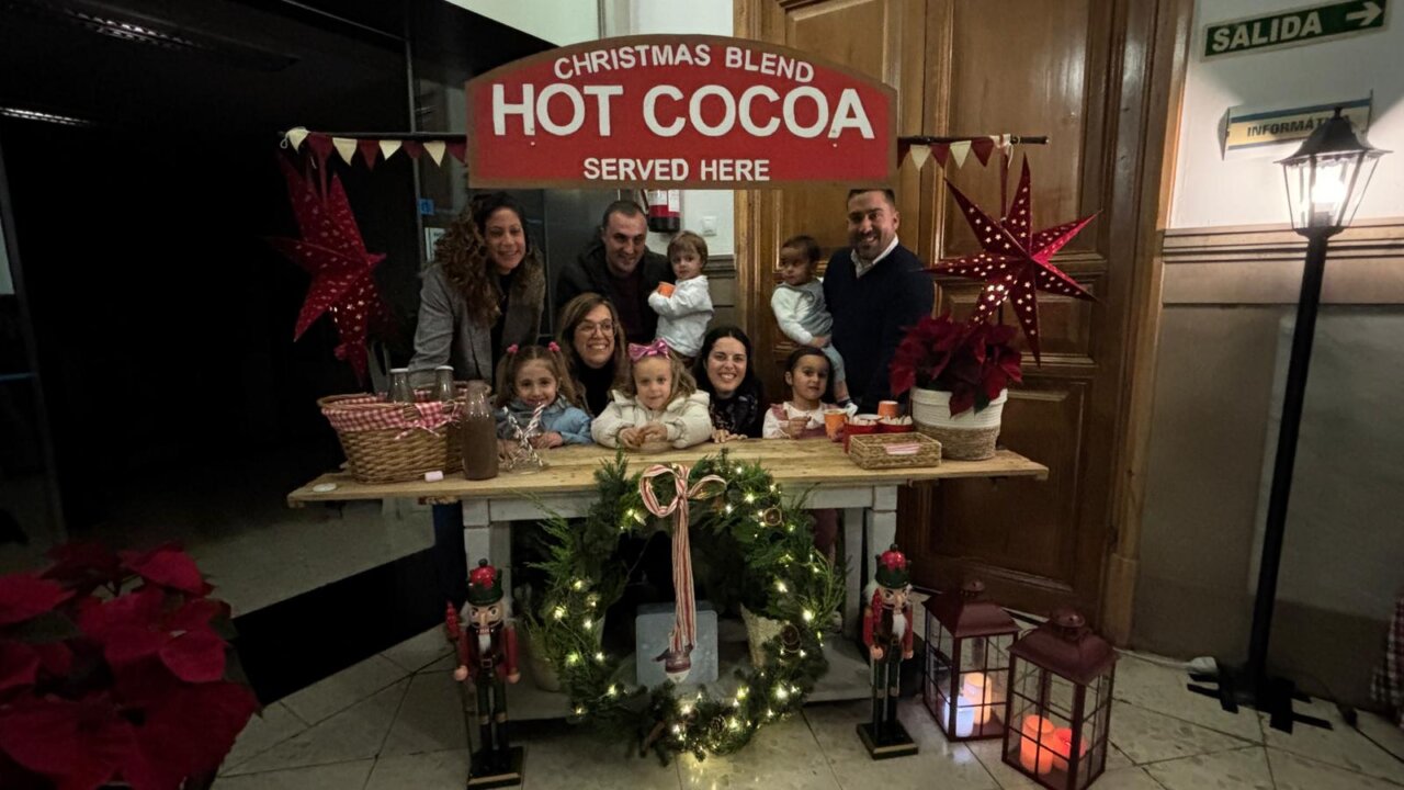 Familia disfrutando de chocolate caliente en evento navideño