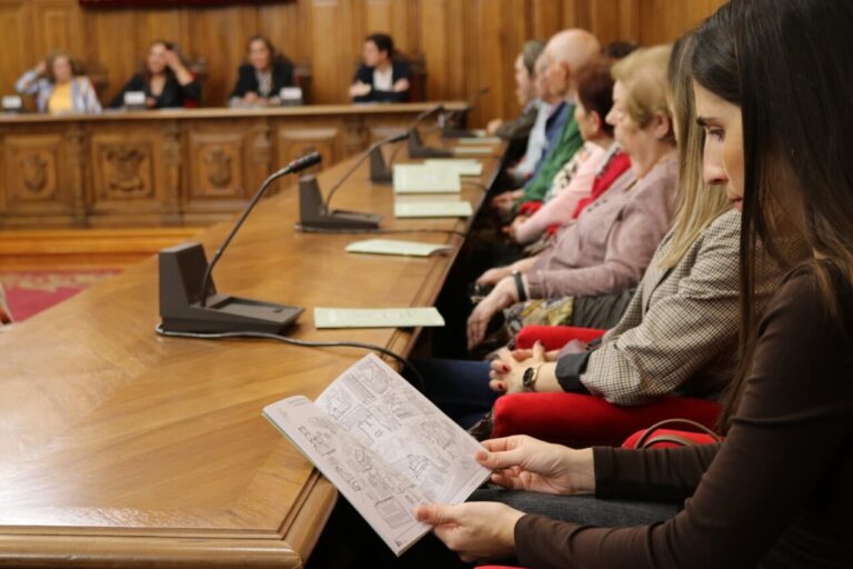 Persona leyendo un cuaderno en una reunión del Ayuntamiento de Palencia