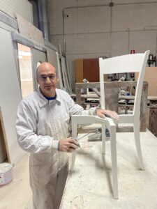 José Luis Barcenilla trabajando en el barnizado de una silla blanca