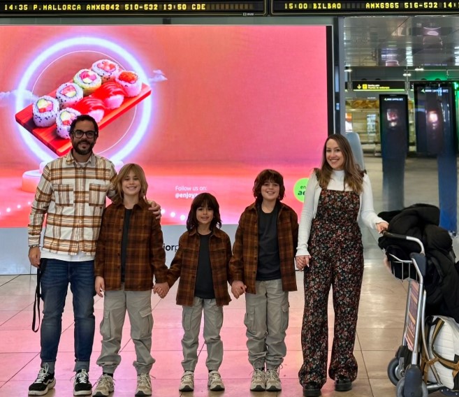 Familia de influencers en el aeropuerto, listos para un viaje familiar.