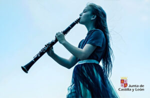 Niña tocando un clarinete en un evento musical de invierno
