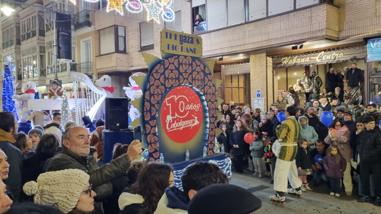 Multitud reunida en una celebración navideña con decoraciones festivas.