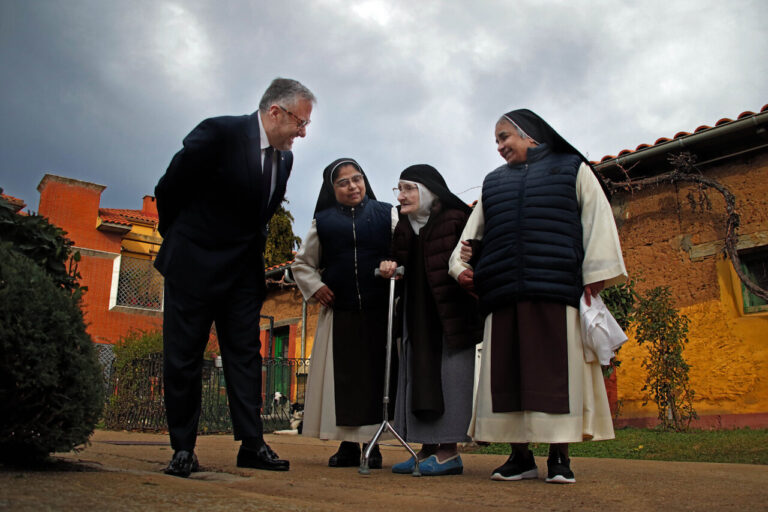 Cuatro personas conversando en un entorno conventual en Palencia