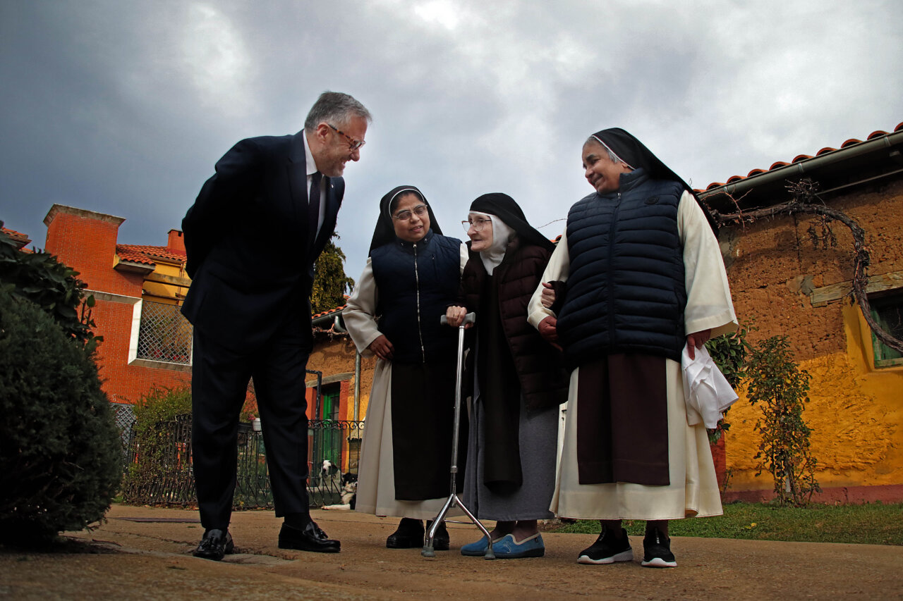 Cuatro personas conversando en un entorno conventual en Palencia