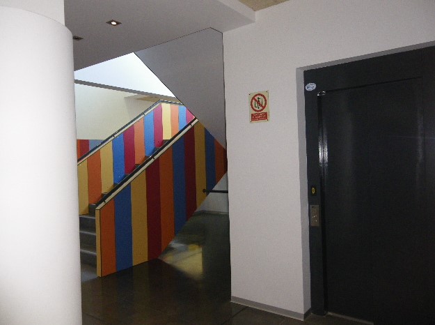 Escalera con colores geométricos en un edificio escolar moderno.