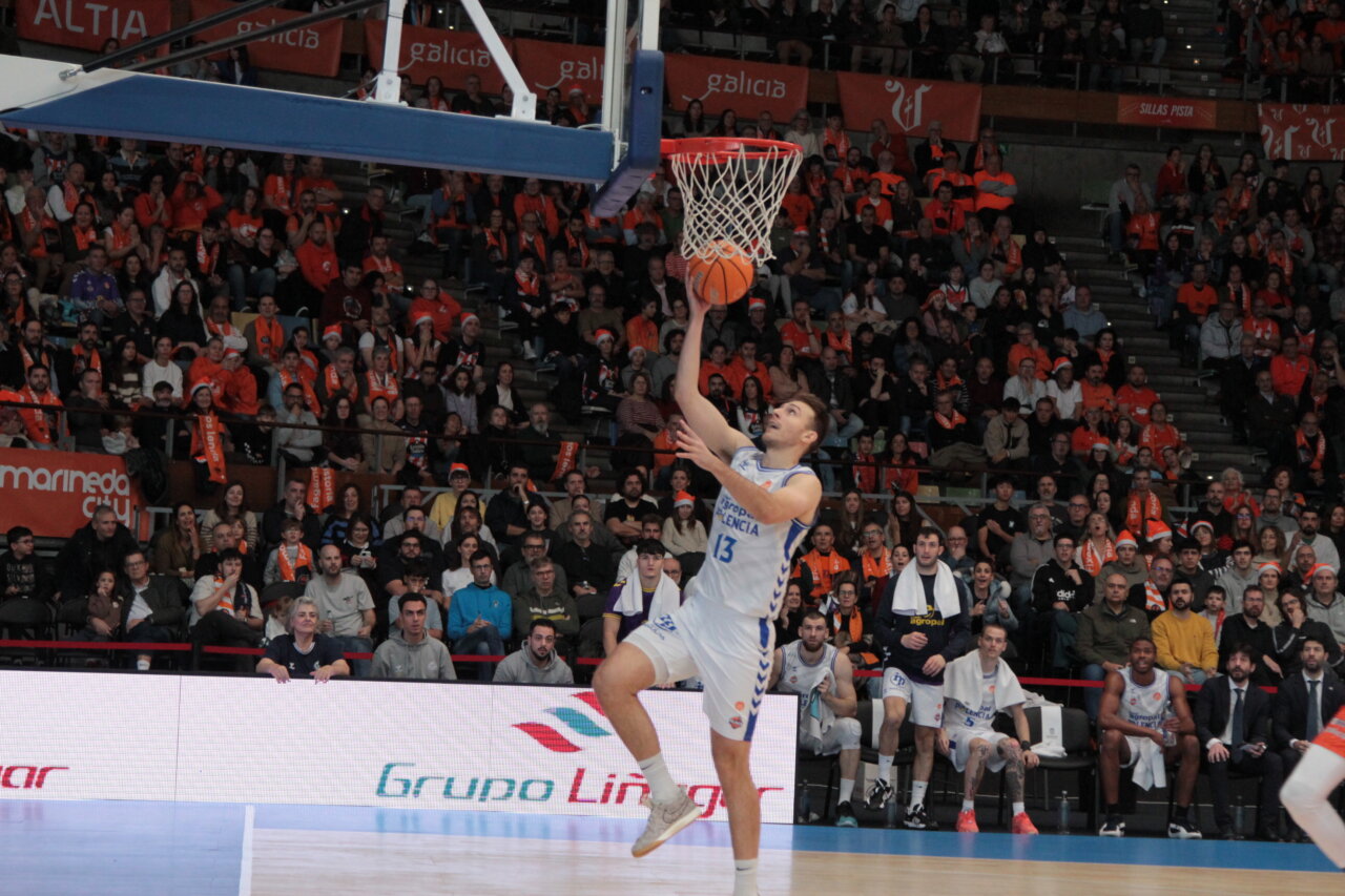 Jugador del equipo de Palencia realizando un salto para encestar en un partido de baloncesto.