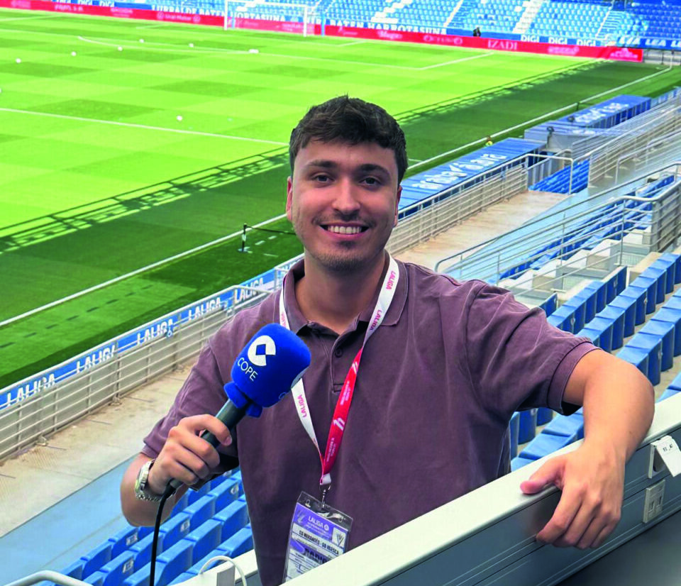 Dani Blázquez posando con un micrófono en un estadio de fútbol