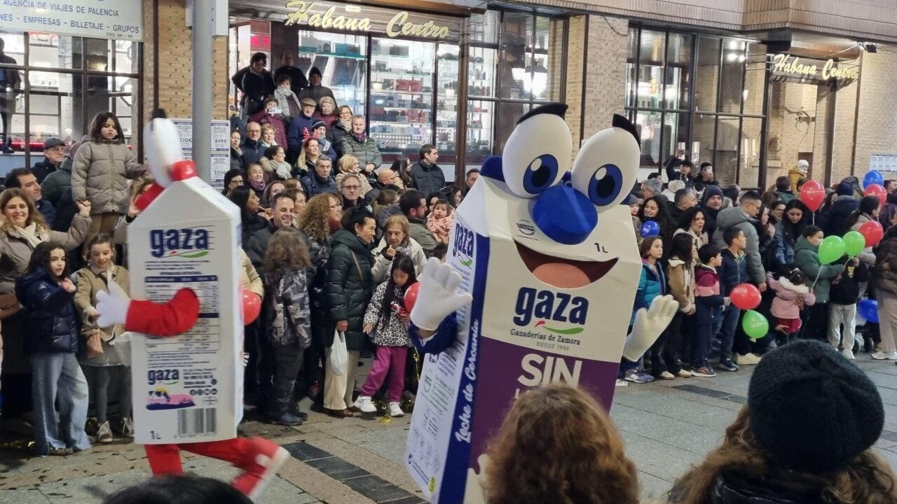 Personaje de cartón de leche GAZA en un desfile con una multitud de espectadores.