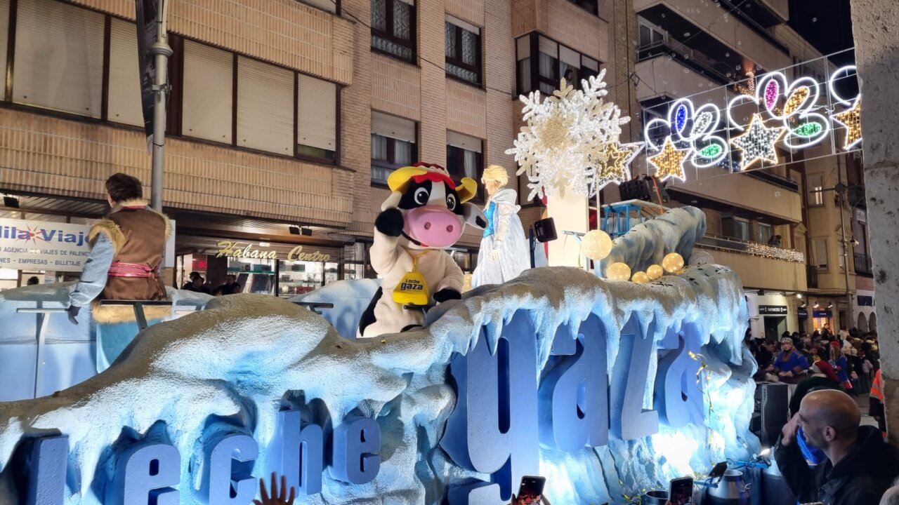 Desfile navideño con una vaca mascota y decoración festiva