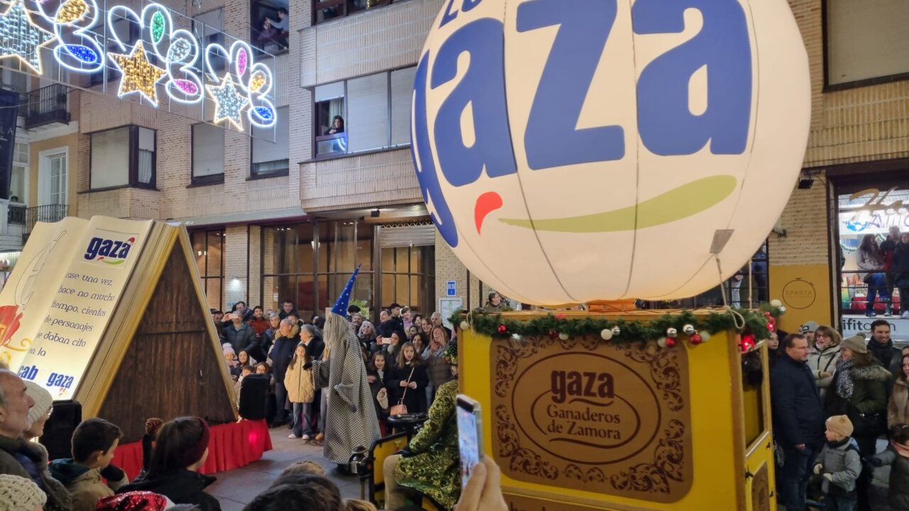 Desfile navideño con un globo y una multitud en Palencia.