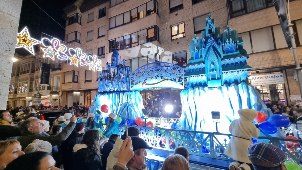 Desfile navideño en Palencia con carrozas iluminadas y público emocionado.