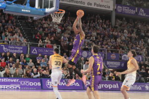 Jugador del Palencia realizando un mate durante un partido de baloncesto