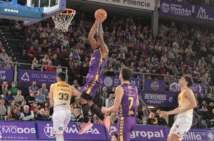 Jugador del Palencia realizando un mate durante un partido de baloncesto