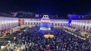 Plaza Mayor de Palencia iluminada con luces navideñas y una gran campana decorativa.