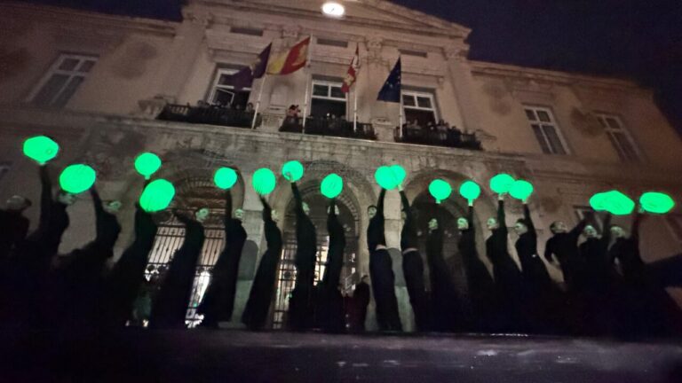 Grupo de personas con luces verdes durante el encendido navideño en Palencia