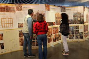 Visitantes observando paneles de la exposición sobre retablos renacentistas