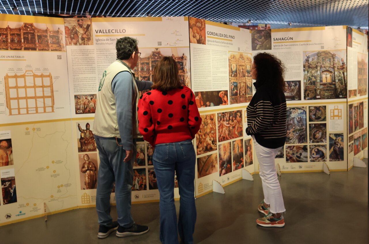 Visitantes observando paneles de la exposición sobre retablos renacentistas