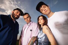 Cuatro artistas posando juntos al aire libre durante el festival Navidad Sonora