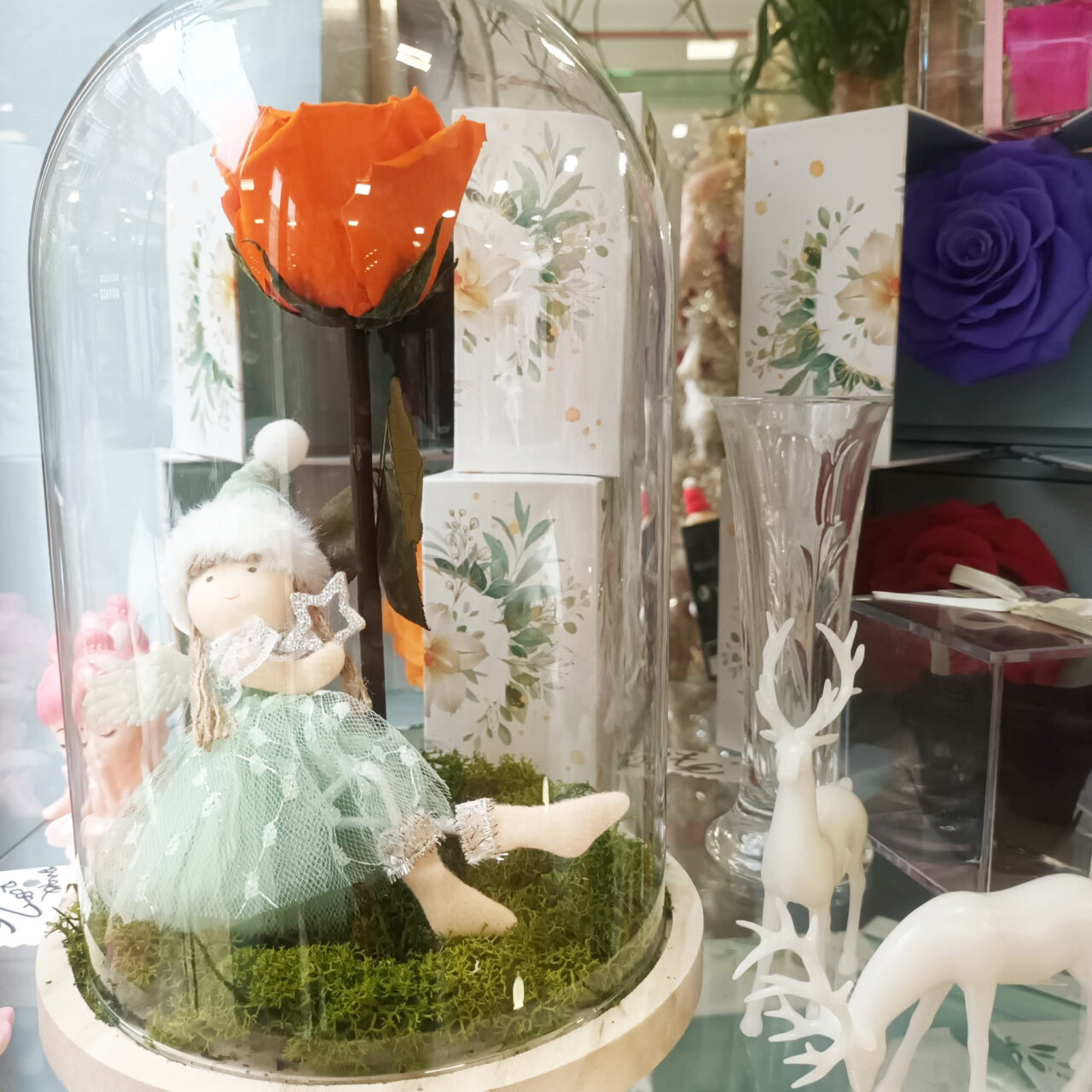 Adorno navideño con flor de lis y muñeca en vitrina