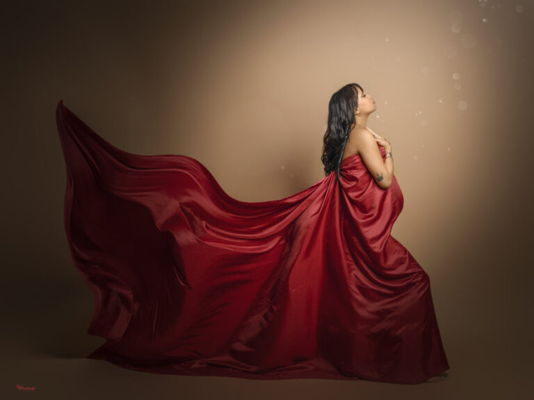 Mujer embarazada con vestido rojo en sesión fotográfica artística