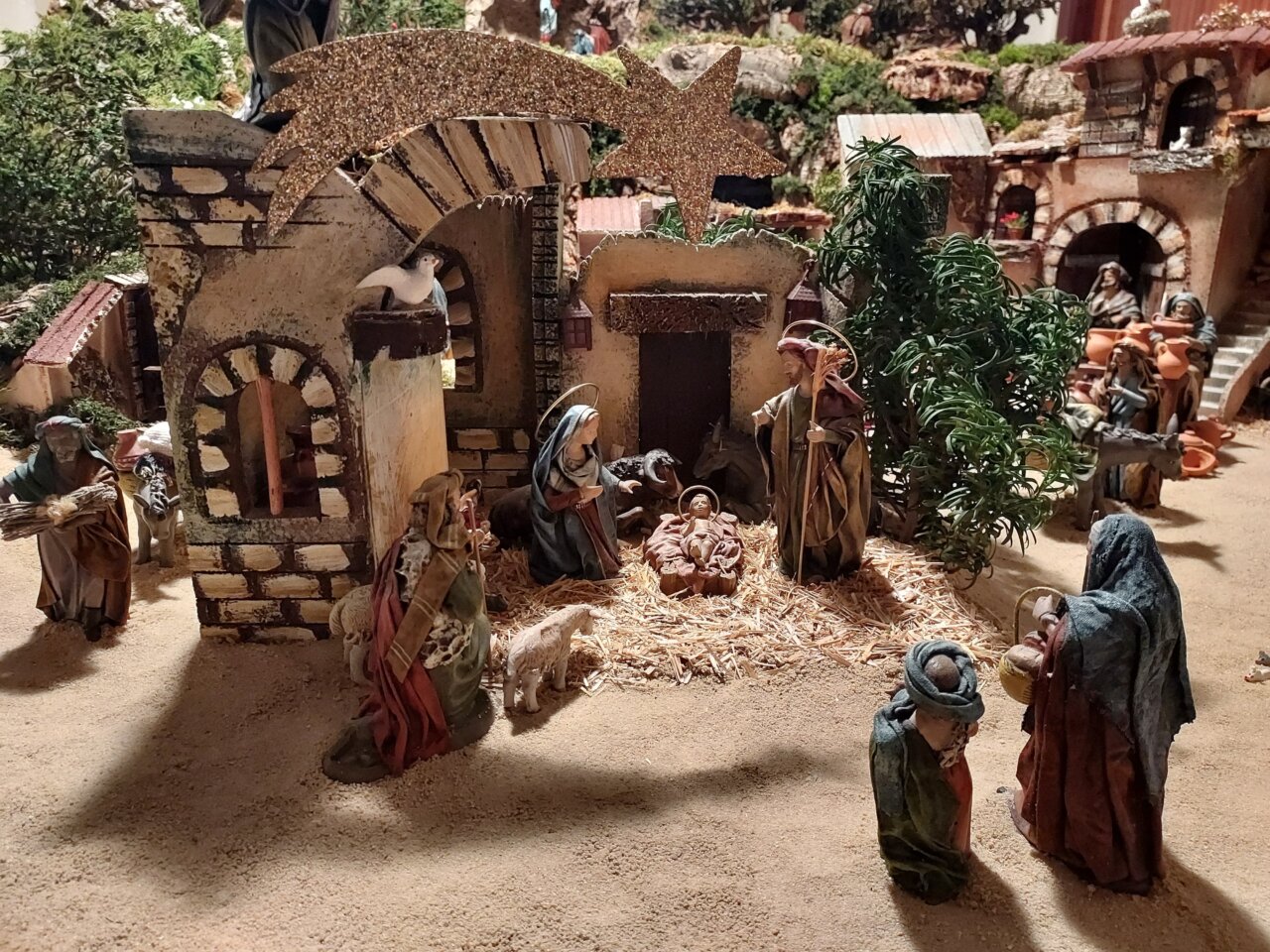 Belén familiar con figuras en un entorno navideño