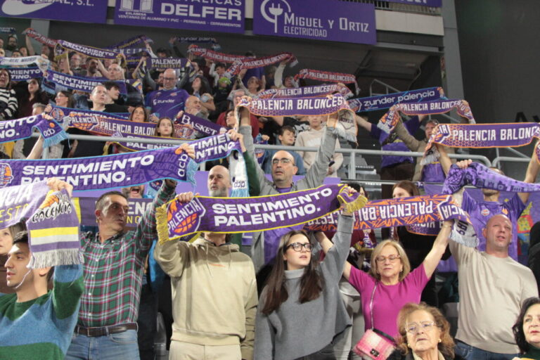 Aficionados animando con bufandas en un partido de baloncesto