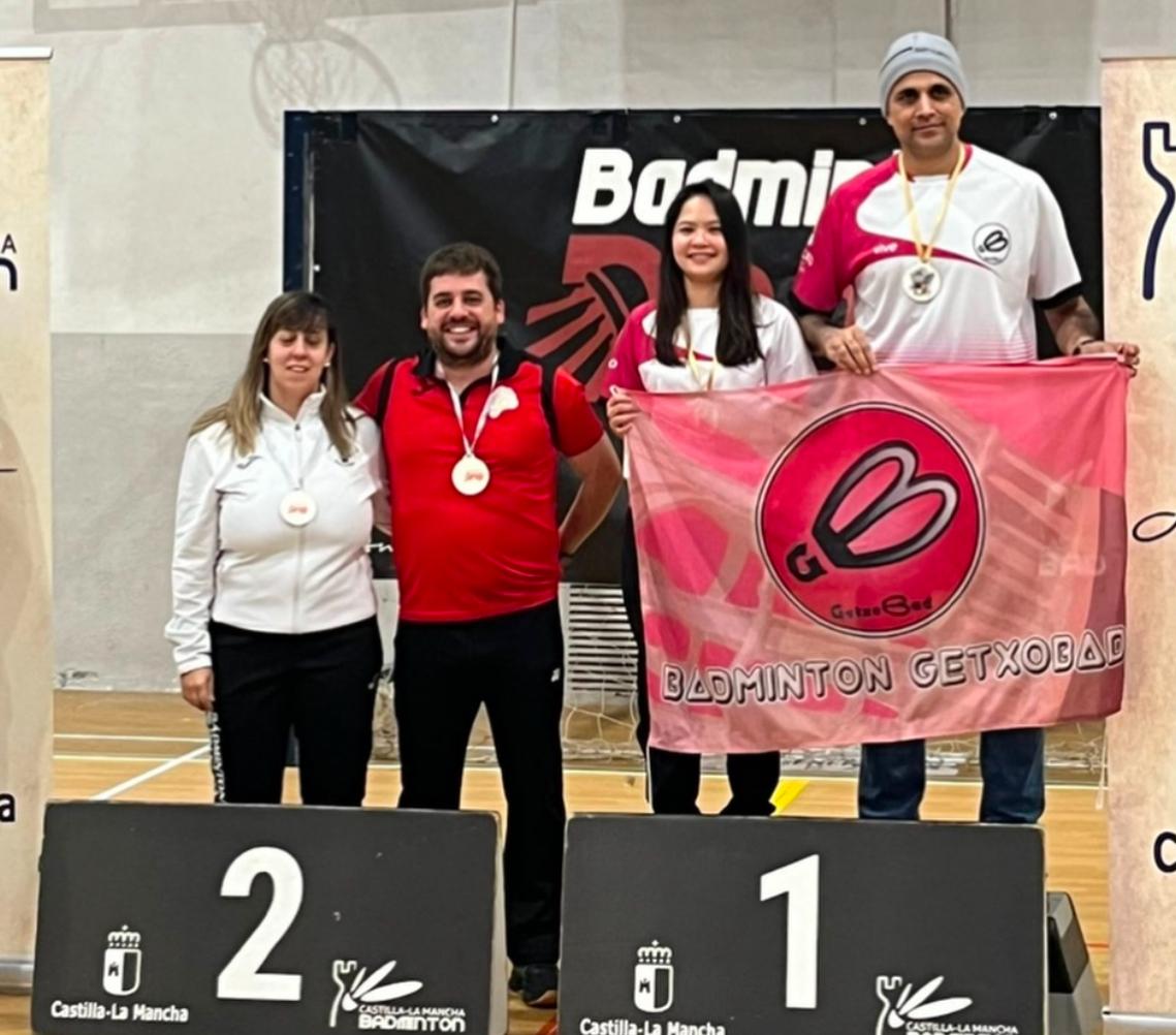 Jugadores del Badminton Club Palencia en un torneo con medallas y bandera