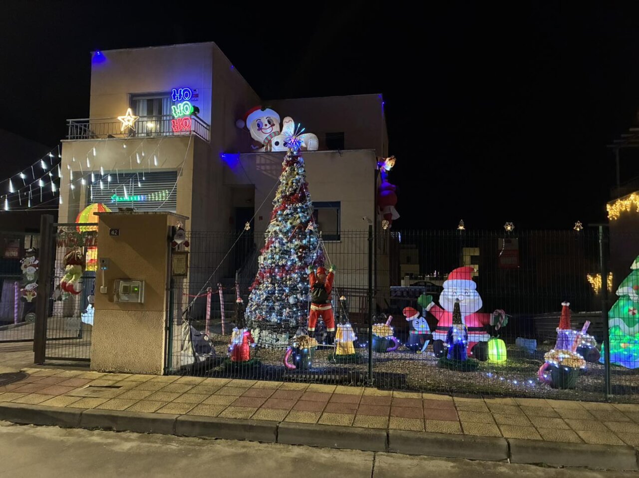 Fachada decorada con luces y adornos navideños en Grijota