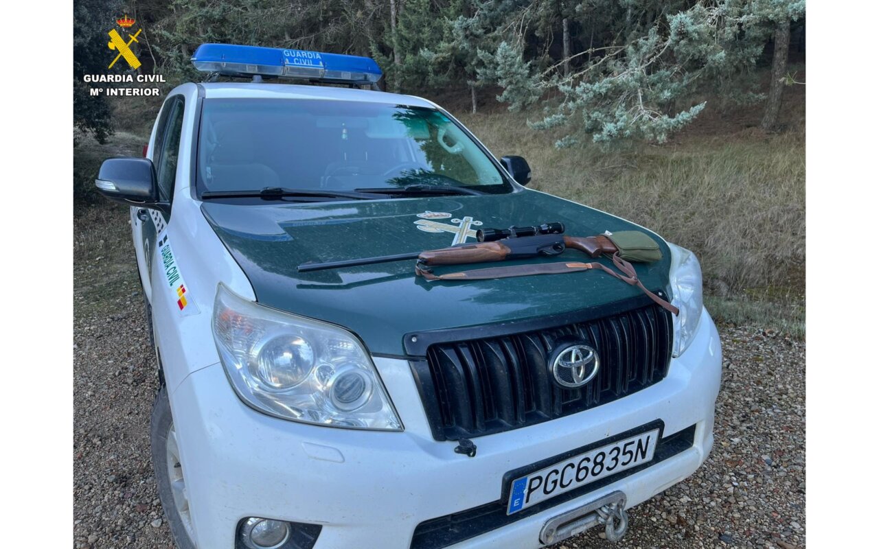 Vehículo de la Guardia Civil con un rifle en el capó en un coto de caza