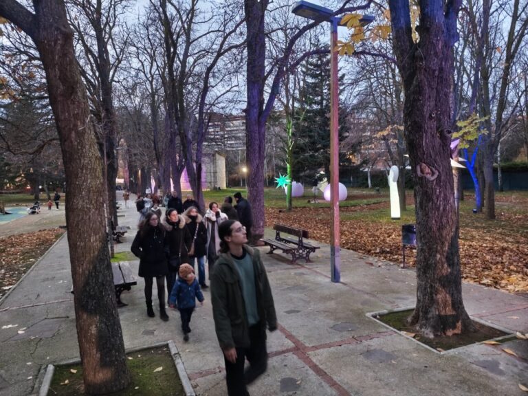 Familias paseando en el Jardín de la Fantasía con luces navideñas