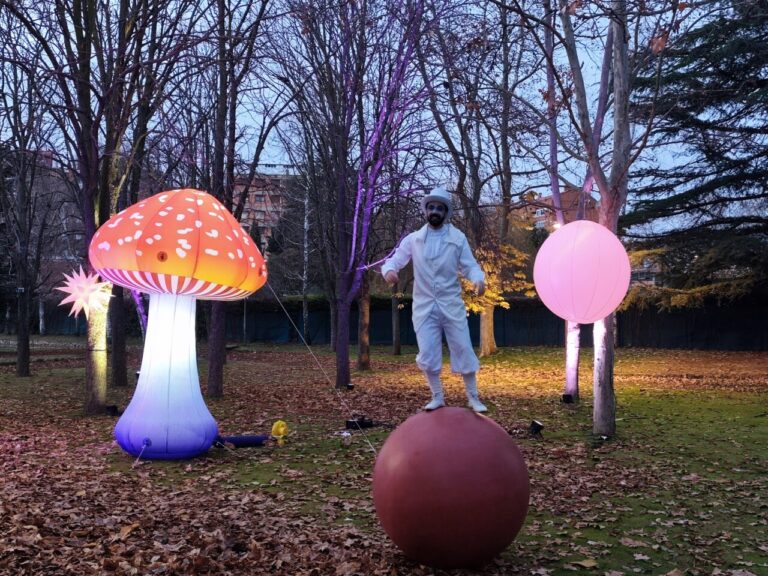Personaje de circo sobre una bola en un jardín iluminado