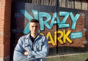 Entrada de Krazy Park con un mural colorido y una persona frente a él