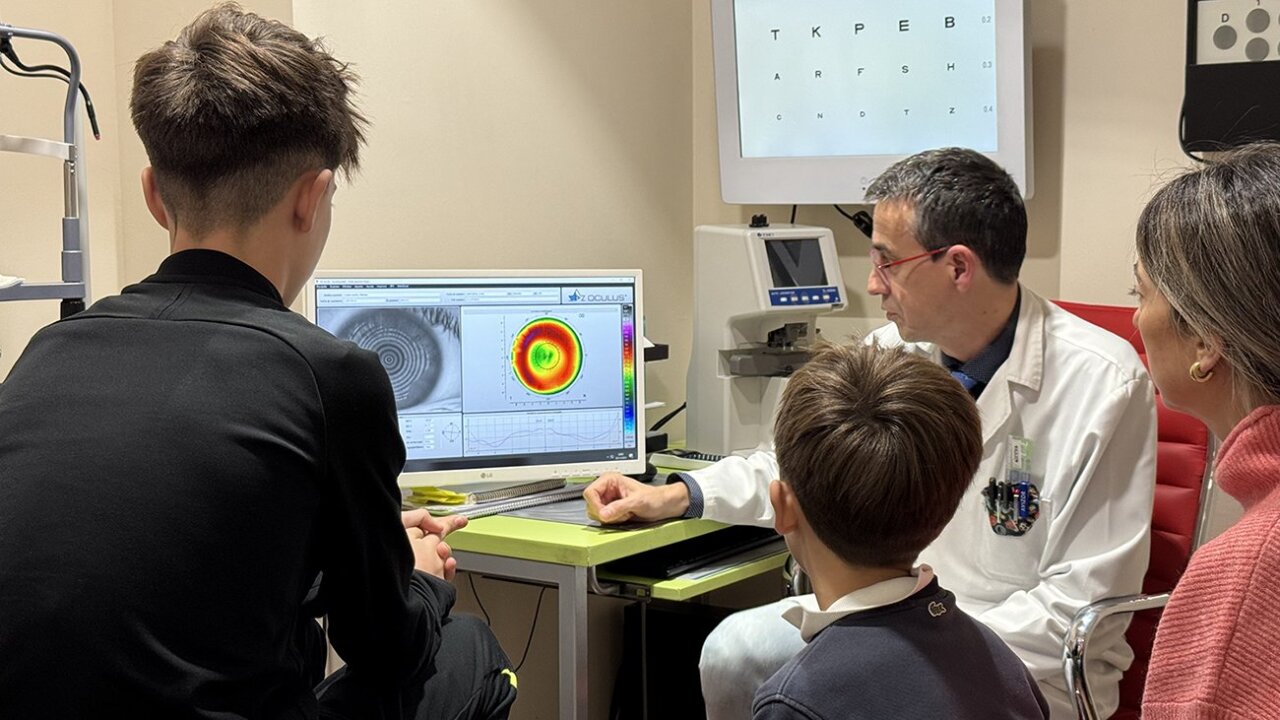 Un joven atleta en consulta con un óptico-optometrista revisando su tratamiento Orto-K.