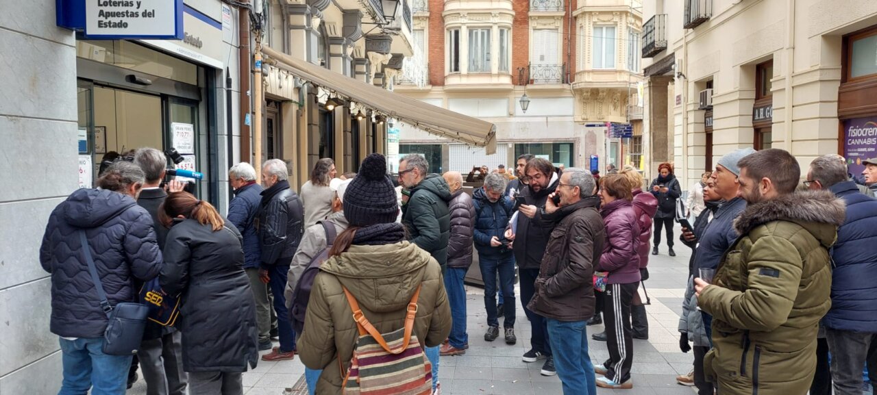 Gente haciendo cola frente a la administración de loterías en Barrio y Mier