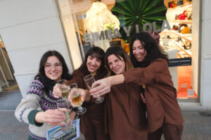 Cinco trabajadoras de Bimba & Lola celebrando con copas tras ganar la lotería