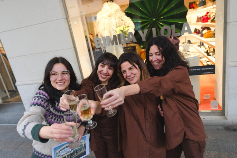 Cinco trabajadoras de Bimba & Lola celebrando con copas tras ganar la lotería