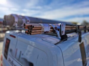 Furgoneta con tubos de cobre mal asegurados en el techo