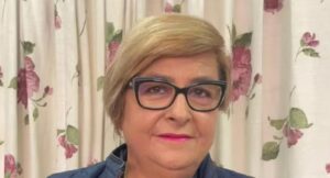 Montse de las Heras sonriente con fondo floral