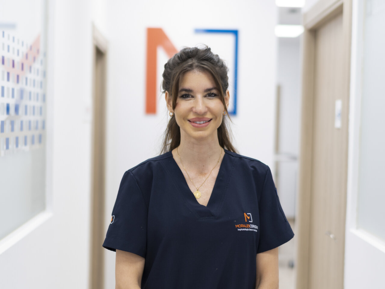 Mujer sonriente en uniforme de clínica dental en un entorno profesional