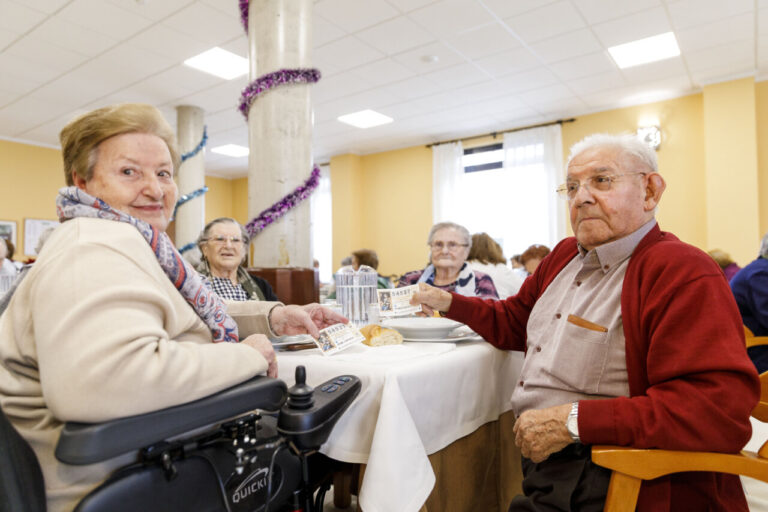 Personas mayores disfrutando de un evento musical en una residencia.