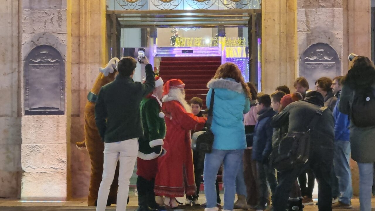 Grupo de personas interactuando con Santa Claus en un evento navideño.