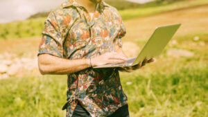 Hombre usando un ordenador portátil en un campo agrícola