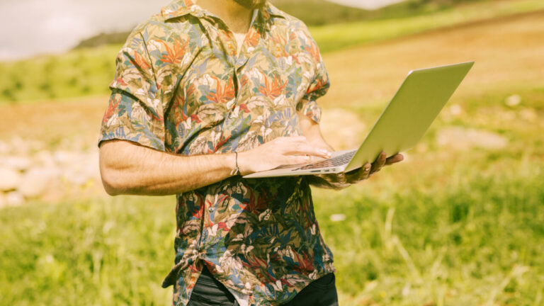 Hombre usando un ordenador portátil en un campo agrícola