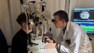Joven atleta en consulta óptica con un optometrista realizando un examen ocular